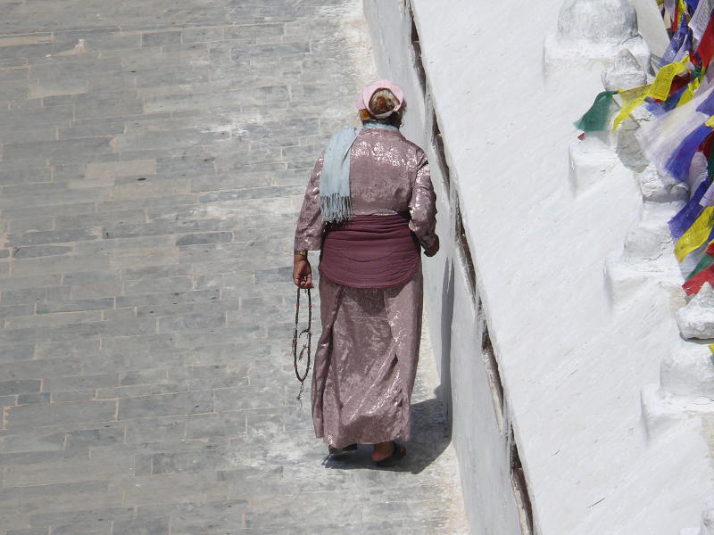 Buddhistin beim Gebetmühlen antreiben 